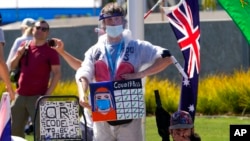 Anti-vaccination protesters demonstrate outside Melbourne Park after Serbia's Novak Djokovic was believed to be held at an immigration detention hotel in Melbourne, Australia, Jan. 15, 2022.