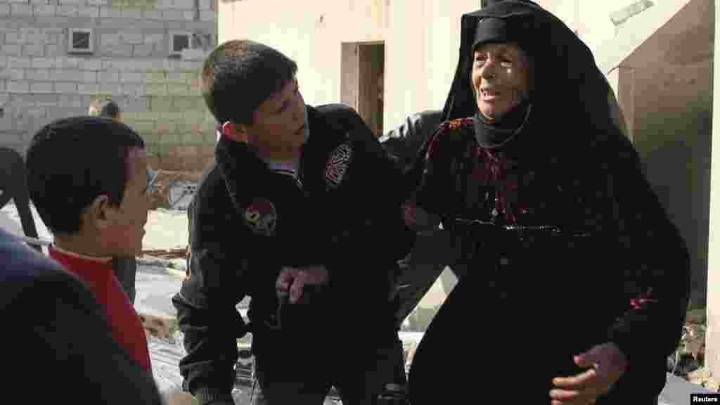 A woman reacts after what activists said was shelling from forces loyal to Syria's President Bashar al-Assad in Al-Atareb, Aleppo countryside, Feb. 16, 2014.