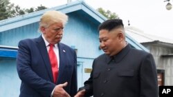 ARCHIVO - El líder norcoreano Kim Jong Un, a la derecha, y el presidente de Estados Unidos, Donald Trump, se disponen a estrecharse la mano en la aldea fronteriza de Panmunjom, en la Zona Desmilitarizada, Corea del Sur, el 30 de junio de 2019.