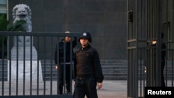 Security personnel stand guard outside as Chinese human rights lawyer Ding Jiaxi stands trial at a court in Haidian District, Beijing, April 8, 2014.