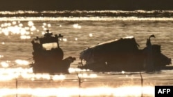 Parte de los restos de un avión de pasajeros que colisionó con un helicóptero militar pueden verse mientras los equipos de rescate buscan en las aguas del río Potomac, cerca de Washington, el 30 de enero de 2025.