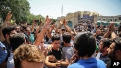 FILE - A group of protesters chant slogans at the main gate of the Old Grand Bazaar, in Tehran, Iran.