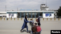 阿富汗乘客從喀布爾的哈米德·卡爾扎伊國際機場前走過。(2016年3月29日)