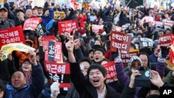 Para demonstran bersorak menyambut berita mengenai pemakzulan Presiden Korea Selatan Park Geun-hye, di depan Majelis Nasional di Seoul (9/12). (AP/Ahn Young-joon)