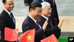 資料照：中共總書記、中國國家主席習近平與越共總書記阮富仲向舉著中越國旗的歡迎人士揮手致意。(2017年11月12日)