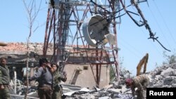 Pejuang dari Unit Perlindungan Rakyat Kurdi (YPG) memeriksa kerusakan di markas mereka setelah terkena serangan udara Turki di Gunung Karachok dekat Malikiya, Suriah, 25 April 2017.