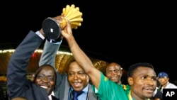 Le capitaine de l’équipe zambienne, vainqueur de la coupe d’Afrique 2012 Christopher Katongo à droite, et juste à côté, le président de la fédération zambienne de football, Kalusha Bwalya, tenant le trophée, le 12 février 2012, Libreville.