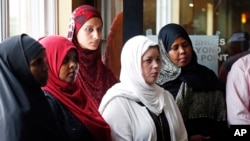 FILE - A group of women listen to Council on American-Islamic Relations-Minnesota Executive Director Jaylani Hussein, speaking about the Somali community concerns about the proposed government-initiated Countering Violent Extremism (CVE) program Thursday, Aug. 6, 2015, in Minneapolis. (AP Photo/Jim Mone) 