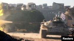 FILE - A Free Syrian Army tank fires in Ramousah area, southwest of Aleppo, Syria, Aug. 2, 2016.