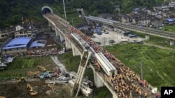 Ma'aikatan ceto, dauke da gawar wani da suka zakulo daga cikin buraguzon jirgin kasa daya goce ya fadi karkashin wata gaba a Wenzhou, lardin Zhejiang kasar China a ranar asabar.