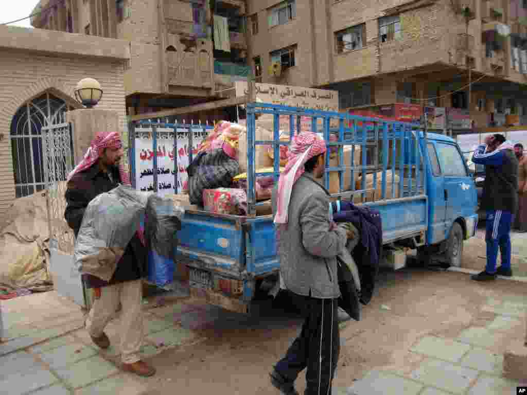 Civilians load their belongings onto a vehicle as they leave their homes after clashes between the Iraqi army and al-Qaida fighters in Fallujah, Jan. 5, 2014.