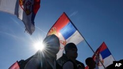Ilustracija - ljudi nose zastave Srbije (AP Photo/Darko Vojinovic)