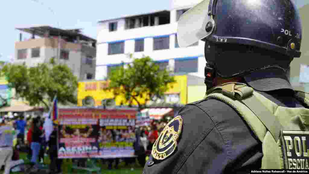 Policías vigilan a los manifestantes que se concentran en las inmediaciones del Centro de Convenciones de Lima, este jueves 14 de noviembre de 2024. 