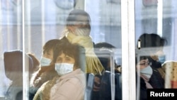 Para penumpang bus di Pyongyang, Korea Utara mengenakan masker sebagai tindakan preventif menghadapi virus korona, 23 Februari 2020. (Foto: Kyodo/via REUTERS).
