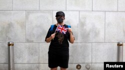 一名香港抗議者在英國駐港總領事館外手舉英國國旗。（2019年8月21日） 