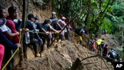 ARCHIVO- Migrantes, en su mayoría venezolanos, caminan a través del Tapón del Darién, de Colombia hacia Panamá, con la esperanza de llegar a Estados Unidos, el 15 de octubre de 2022. 