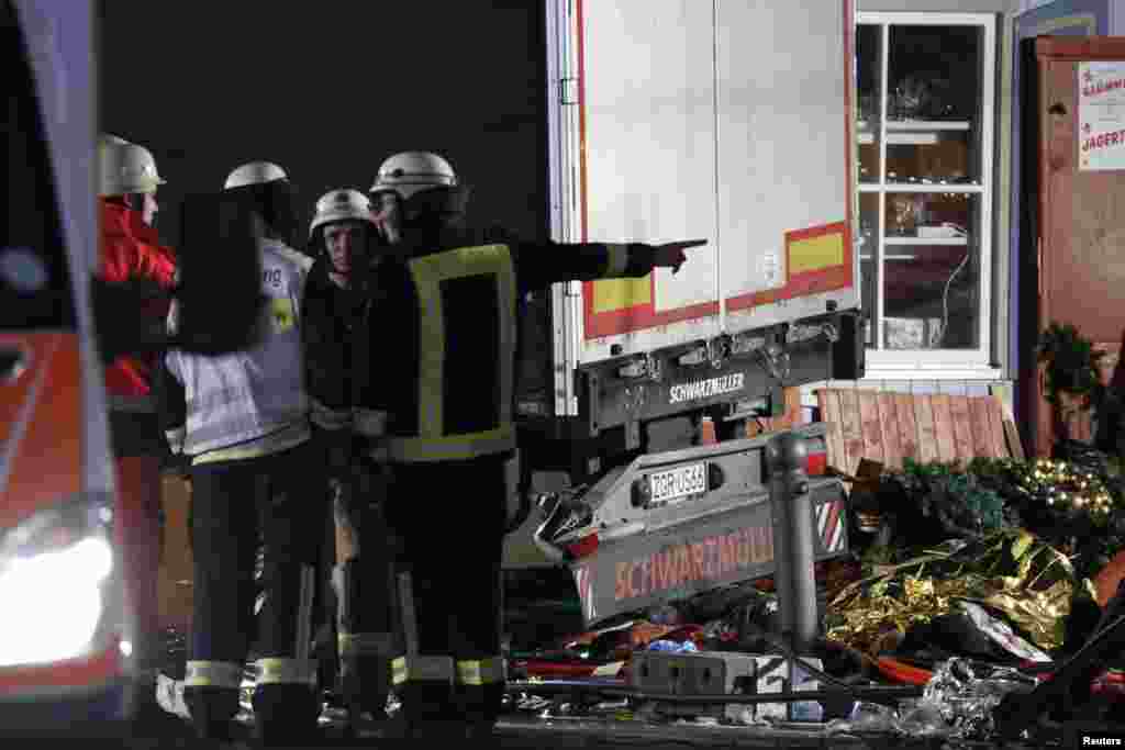 Firefighter stand beside a truck at a Christmas market in Berlin, Dec 19, 2016 after the truck ploughed into the crowded Christmas market in the German capital.