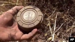 Gambar ranjau darat dari sebuah video yang diambil 7 September 2015 dan dirilis oleh Pusat Pembersihan Ranjau dan Rehabilitasi Suriah, seorang relawan mengambil ranjau darat dari sebuah lahan di Daraa, Suriah. (Foto:Dok)