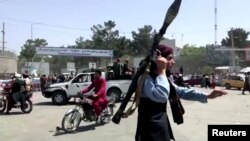 Un miembro del Talibán corre hacia una multitud en el aeropuerto de Kabul, Afganistán, el 16 de agosto de 2021, en una captura de video divulgada por Reuters.