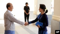 Presiden Myanmar Thein Sein (kiri) berjabat tangan dengan pemimpin oposisi Aung San Suu Kyi sebelum pertemuan di istana kepresidenan di Naypyitaw (31/10).