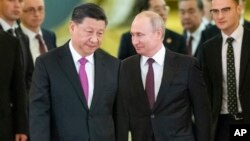 Russian President Vladimir Putin, right, and Chinese President Xi Jinping enter a hall for the talks in the Kremlin in Moscow, Russia, June 5, 2019.