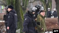 2024 年 2 月 17 日俄羅斯反對派領導人阿列克謝·納瓦爾尼在北極死亡一天後,俄羅斯聖彼得堡警察抓捕前去政治鎮壓受害者紀念碑前給納瓦爾尼獻花的民眾。圖為一名男子被警察帶走。