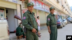 Tentara Etnis Kokang berjaga di depan sebuah toko di Lauk Kai, perbatasan China-Myanmar (Foto: dok). 