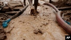 A man walks on special carpets that are used to filter earth and water in search of gold at an illegal mine site, file photo.