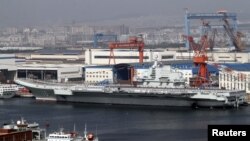 Para tentara angkatan laut Tiongkok terlihat berdiri di atas geladak kapal induk pertama Tiongkok "Lioning" yang berlabuh di pelabuhan Dahlian, propinsi Liaoning, bagian timur laut Tiongkok (25/9).