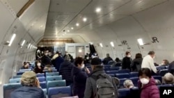 Imagen tomada de un video el lunes 17 de febrero de 2020, pasajeros del crucero en cuarentena Diamond Princess esperan a volar hacia Estados Unidos desde el aeropuerto de Haneda, en Tokio. (Cheryl y Paul Molesky via AP)