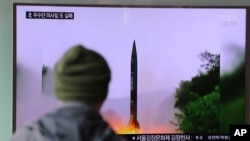 Seorang pria di sebuah stasiun kereta di Seoul, Korea Selatan, menonton berita di televisi mengenai peluncuran misil Korea Utara Kamis pagi (20/10).