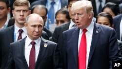 Presiden Rusia Vladimir Putin (kiri) berbicara dengan Presiden AS Donald Trump di sela-sela KTT APEC di Danag, Vietnam, 11 November 2017.