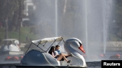 Una pareja pasea en un bote de pedales en Echo Park, Los Ángeles, California. 13 de agosto de 2020.