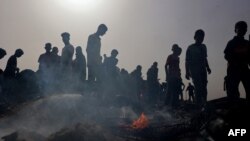Palestinos se reúnen en el lugar de un ataque israelí contra un campamento de desplazados internos en Rafah el 27 de mayo de 2024.