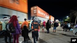 Migrantes observan el paso de un tren mientras esperan por otro tren hacia el norte para abordarlo en Irapuato, México, el 23 de septiembre de 2023.