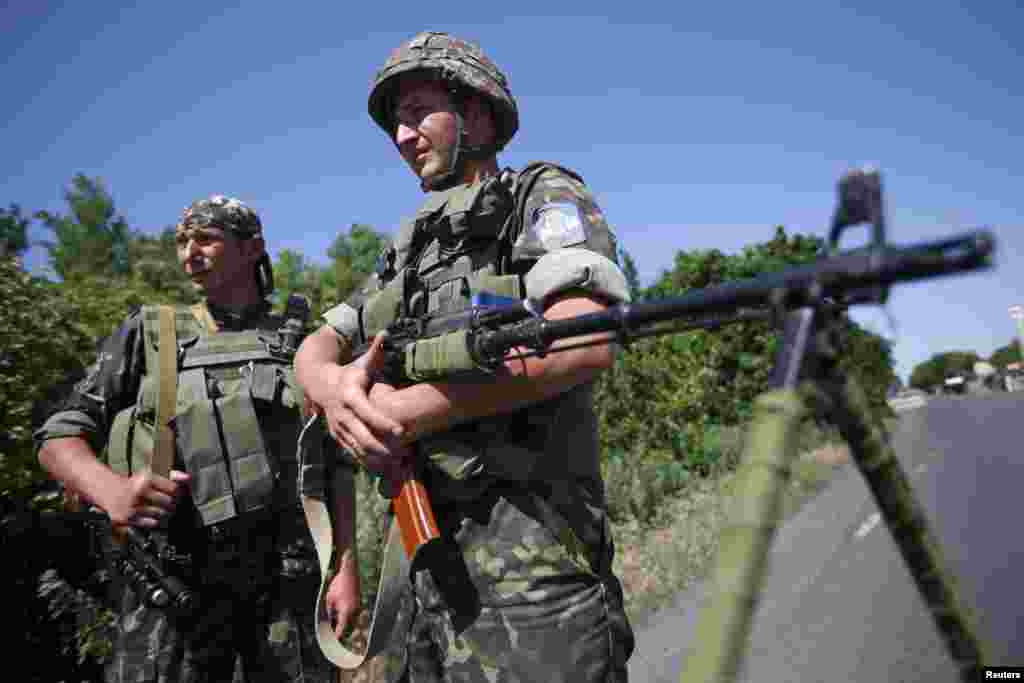 Ukrainian servicemen stand guard at a checkpoint near the town of Amvrosievka, in Donetsk region, Ukraine, June 5, 2014.