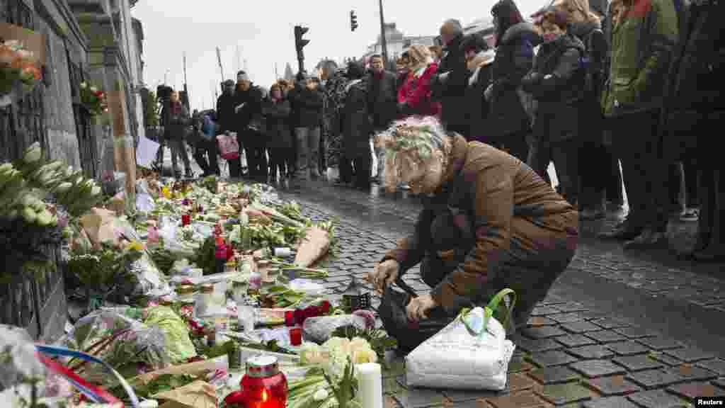 Des gens déposent des fleurs lors d'une minute de silence en face de l'ambassade française à Copenhague, au Danemark, le 8 janvier 2015.