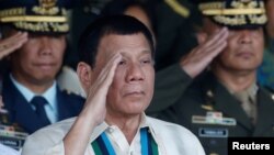 Presiden Filipina Rodrigo Duterte memberi hormat dalam perayaan ulang tahun militer negara itu di kota Quezon, Manila (21/12). (Reuters/Erik De Castro)