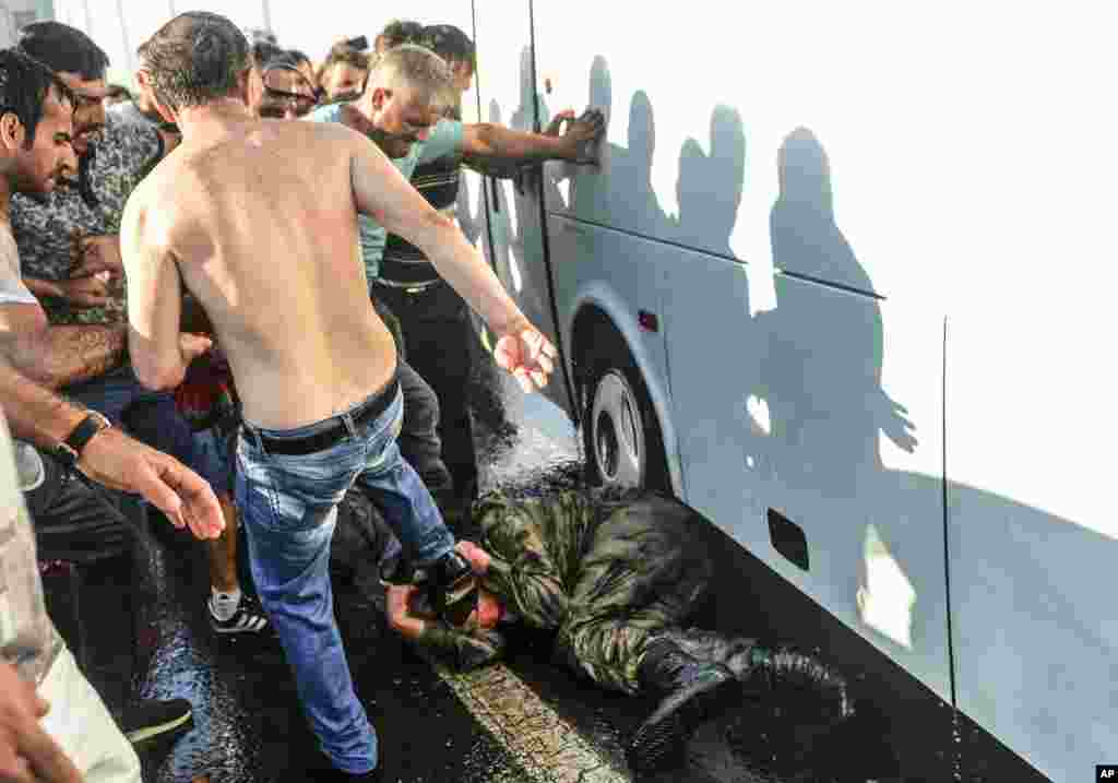People kick and beat a Turkish soldier, who participated in the attempted coup, on Istanbul's Bosporus Bridge, July 16, 2016.