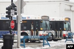 Autobuses de la Autoridad de Tránsito de Chicago en la zona de llegada de migrantes durante una tormenta invernal el 12 de enero de 2024 en Chicago, Illinois. (Foto de KAMIL KRZACZYNSKI / AFP)