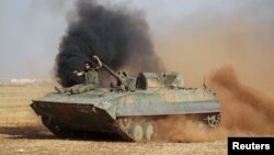 Des combattants rebelles conduisent un véhicule militaire à la périphérie de Tell Rifaat town, au nord d’Alep et contrôlée par les Forces Démocratiques de syrie (SDF) Syrie, le 22 octobre 2016. 