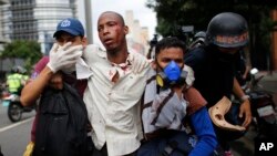 Des paramédicaux portent secours à un homme blessé lors des affrontements entre manifestants et forces de l'ordre à Caracas, Venezuela, le 20 avril 2017.