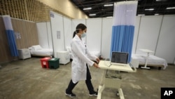 Un médico traslada un equipo en un hospital de campaña establecido dentro del centro de convenciones Corferias en Bogotá, Colombia, el lunes 20 de abril de 2020.