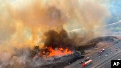 In this photo released by the Los Angeles County Fire Department Air Operations traffic passes the Route fire, a brush wildfire off Interstate 5 north of Castiac, Calif., on Sept. 11, 2021.