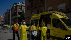 Health personnel wearing protection gear to protect against the spread of the new coronavirus prepare to attend to a patient during the COVID-19 virus outbreak in Barcelona, Spain, April 6, 2020.