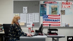 Sue Ziel, a sixth grade social studies teacher at Romeo Middle School, works in her classroom in Romeo, Mich., Tuesday, April 27, 2021. (AP Photo/Paul Sancya)