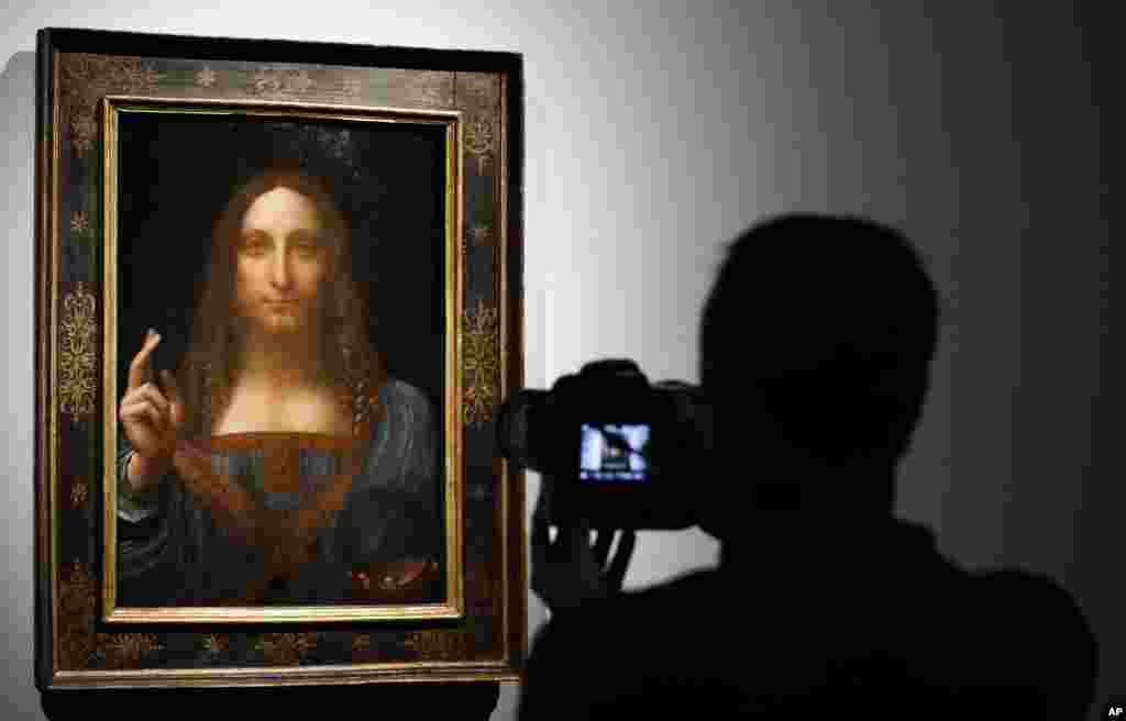 Wani mutumi yana daukar hoton zanen "Salvator Mundi" na Leonardo da Vinci a gidan gwanjo na Christie's a London, 24 Oktoba, 2017.