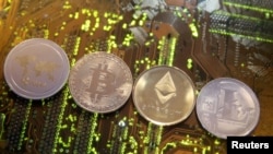 FILE - Representations of the Ripple, Bitcoin, Etherum and Litecoin virtual currencies, Feb. 13, 2018. Switzerland's government wants to look into the feasibility of launching its own state-backed cryptocurrency.