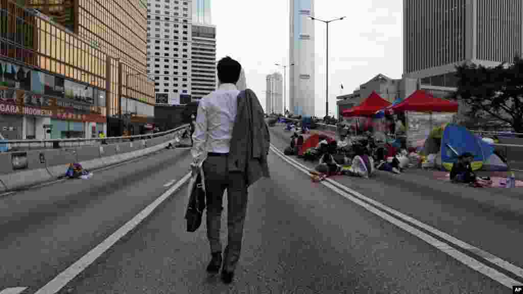被占政府总部大楼路边： 行人走路上班； 抗议学生路边睡觉 