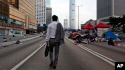 홍콩 정부 청사 주변에 텐트 농성을 벌이던 학생들이 잠들어 있는 6일 한 남성이 출근길에 그 옆을 지나고 있다.